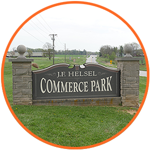 Entrance sign to the J.F. Helsel Commerce park with Highway 56 in the distance.
